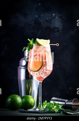 Französischer Orangenmuli, alkoholischer Cocktail mit Wodka, Limettensaft, Ingwerbier, Sirup, roter Orangensaft und Eiswürfel, garniert mit Minze. Dunkle Hintergrundebene Stockfoto