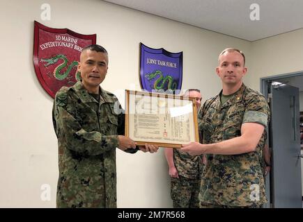 General Shingo Nashinoki, Befehlshaber der Amphibien-Schnelleinsatzbrigade, 陸上自衛隊 Japan Ground Self-Defense Force, stellte fünf US-Dollar vor Marineoffiziere der Marine Expeditionary Brigade 3. mit Dankestiteln an Bord von Camp Courtney, Okinawa, Japan, 11. Mai 2022 zu Ehren unserer engen Beziehung und harten Arbeit bei vergangenen Veranstaltungen wie den jährlichen Übungen Yama Sakura, die die Verteidigung Japans Proben. Oberst Michael 'Spud' Brennan, Operations Officer der MEB 3D, überreichte der ARDB CG ebenfalls ein kleines Geschenk, das unser gemeinsames Ziel und unser Engagement zum Ausdruck brachte Stockfoto