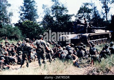 Marinekorps-Infanteristen der Kompanie B, 1. Bataillon, 3. Marines, 3. Marine-Division, Flotten-Marine-Truppe, Setzen Sie sich um einen M60A1-Tank auf den Boden. Die Besatzung des Panzers, von der 1. Marine Division, Fleet Marine Force, führt Kurse über die Nomenklatur des Panzers durch. Basis: Zambolies Training Area Land: Philippinen (PHL) Stockfoto