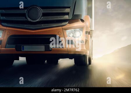 LKW-Transporter bewegt sich schnell auf der Straße mit Sonnenschein im Hintergrund Stockfoto