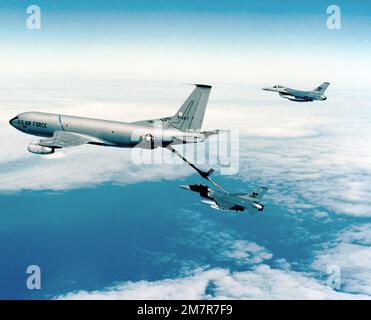 Eine Air-to-Air-Ansicht von links auf ein Flugzeug des Typs KC-135 Stratotanker, das eine F-16A betankt und Falcon bekämpft, während eine weitere F-16 auf ihren Zug wartet. Die F-16s sind vom 35. Taktischen Kampfflugflügel und werden auf den Kunsan-Stützpunkt in Korea entsandt. Land: Pazifik (POC) Stockfoto