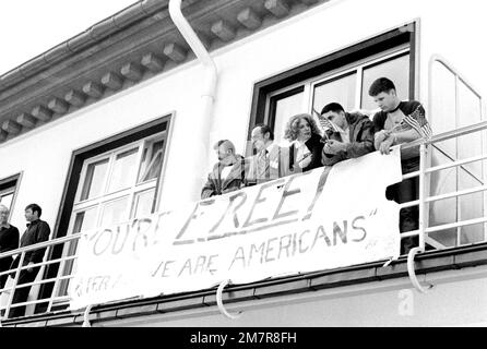 Ehemalige Geiselarmee MSGT Regis Ragan, Richard Morefield, Marine SGT William Gallegos und Marine SGT Paul Lewis, von links nach rechts, sehen Sie das Deutsche Kinderchorus-Straßenkonzert zu Ehren der Geiseln von einem Krankenhausbalkon aus. Die 52 Geiseln verbringen ein paar Tage nach ihrer Freilassung aus dem Iran im Krankenhaus, bevor sie in die Vereinigten Staaten abreisen. Basis: Wiesbaden Luftwaffenstützpunkt Land: Deutschland / Deutschland (DEU) Stockfoto