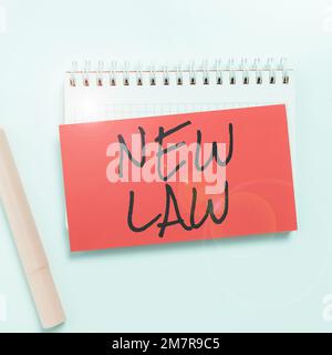Textunterschrift mit „New Law“, ein Wort, das auf einem System von Regeln geschrieben wurde, die durch soziale oder behördliche Vorschriften durchgesetzt werden Stockfoto
