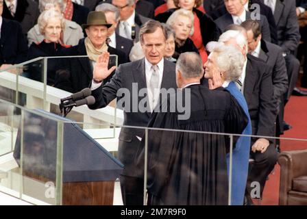 Im Capitol Building leistet George Bush den Amtseid als Vizepräsident der Vereinigten Staaten. Bushs Frau Barbara steht während der Feier des Amtseinweihungstags zu seiner Linken. Basis: Washington State: District of Columbia (DC) Land: Vereinigte Staaten von Amerika (USA) Stockfoto