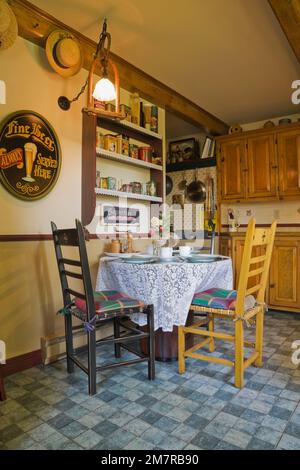 Antike Holzstühle und Frühstückstisch in der Küche im alten rekonstruierten Blockhaus im Stil der 1850er Jahre. Stockfoto