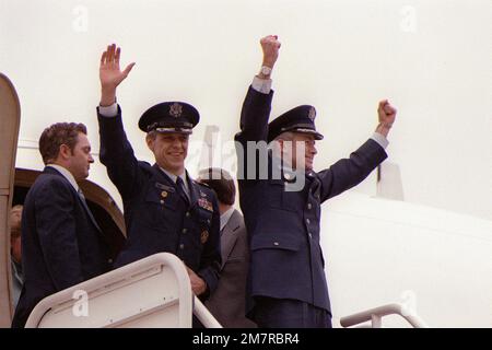 LTC Donald M. Roeder, Left, und COL Thomas E. Schaefer winken den wartenden Leuten zu, bevor sie aus dem Flugzeug aussteigen. Roeder und Schaefer sind zwei ehemalige iranische Geiseln, die nach ihrer Freilassung auf dem Heimweg sind. Basis: Luftwaffenstützpunkt Andrews Bundesstaat: Maryland (MD) Land: Vereinigte Staaten von Amerika (USA) Stockfoto