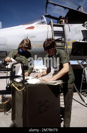 SSGT Karen Forsythe und AMN Steve Miles gehen ein Wartungshandbuch und Instandhaltungsaufzeichnungen für Flugzeuge durch. Die Flieger warten an einem F-15 Eagle-Flugzeug während der Übung Border Star 81. Betreff Operation/Serie: GRENZSTERN '81 Stützpunkt: Luftwaffenstützpunkt Holloman Bundesstaat: New Mexico (NM) Land: Vereinigte Staaten von Amerika (USA) Stockfoto