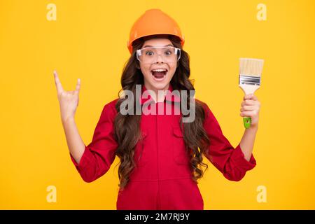 Kleiner Baumeister Experte für Helm auf der Baustelle. Teen Mädchen Maler mit Malerei Pinsel Werkzeug oder Malrolle. Kind bei der Reparatur von Arbeiten. Renovierung Stockfoto