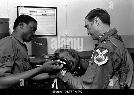 GEN. Charles A Gabriel holt einen Helm vom SENIOR AIRMAN Richard Brown ab, der ein Flugzeug des RF-4C Phantom II fliegt, um den Film „Side Looking Airborne Radar“ zu drehen. Gabriel ist Oberbefehlshaber der US-Luftwaffe in Europa und SENIOR AIRMAN Brown, ein Lebenserhaltungs-Techniker, taktisches Aufklärungsgeschwader 38., taktischer Aufklärungsflügel 26. Basis: Zweibrucken Luftwaffenstützpunkt Land: Deutschland / Deutschland (DEU) Stockfoto