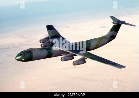 Eine Air-to-Air-Ansicht von links eines C-141B Starlifter-Flugzeugs mit dem neuen europäischen Farbschema. Das Flugzeug trägt den Spitznamen „Green Lizard“. Basis: Südkalifornien Wüstenstaat: Kalifornien (CA) Land: Vereinigte Staaten von Amerika (USA) Stockfoto