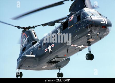 Eine Ansicht von rechts unter einem CH-46D Sea Knight Helikopter von Helicopter Combat Support Squadron 3 (HC-3), Ablösung 103. Der Hubschrauber ist dem Munitionsschiff der Kilauea-Klasse USS KISKA (AE 35) zugewiesen. Land: Unbekannt Stockfoto