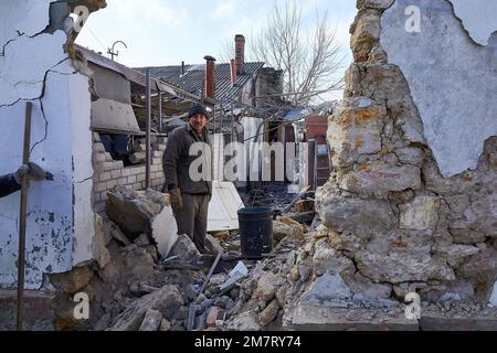 Kherson, Ukraine. 10. Januar 2023. Aleksei steht am Eingang seines zerstörten Hauses. Aleksei, 62, und sein Zwillingsbruder Sergei wurden heute Abend von einer russischen Rakete getroffen. Aleksei, der im Wohnzimmer saß, wurde von Schutt von der Wand getroffen, der seinen Kopf verletzt hat. Kredit: SOPA Images Limited/Alamy Live News Stockfoto