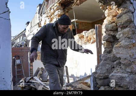 Kherson, Ukraine. 10. Januar 2023. Aleksei verlässt sein beschädigtes Haus, um für seine Verletzungen ins Krankenhaus zu gehen. Aleksei, 62, und sein Zwillingsbruder Sergei wurden heute Abend von einer russischen Rakete getroffen. Aleksei, der im Wohnzimmer saß, wurde von Schutt von der Wand getroffen, der seinen Kopf verletzt hat. Kredit: SOPA Images Limited/Alamy Live News Stockfoto