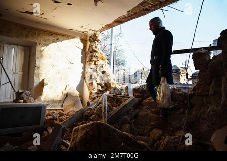 Kherson, Ukraine. 10. Januar 2023. Ein Mann geht auf den Trümmern eines zerstörten Hauses in der Stadt Kherson, nach schweren russischen Bombenangriffen. Am Nachmittag des Monats 9. beschossen russische Truppen die Stadt Kherson mit einem heftigen Beschuss, der Dutzende von Häusern, Verletzten und Todesopfern zerstörte. Am Nachmittag des Monats 9. beschossen russische Truppen die Stadt Kherson mit einem heftigen Beschuss, der Dutzende von Häusern, Verletzten und Todesopfern zerstörte. Kredit: SOPA Images Limited/Alamy Live News Stockfoto