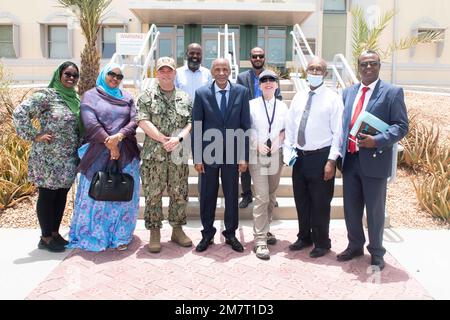 CAMP LEMONNIER, Dschibuti (12. Mai 2022) USA Marinekapitän Brian Iber, kommandierender Offizier von Camp Lemonnier, Dschibuti (CLDJ), und der Ehrenmann Omar Abdi sagten, Arbeitsminister von Dschibuti und Mitglieder ihrer Mitarbeiter stehen für ein Gruppenfoto bei CLDJ am 12. Mai. Herr Said besuchte Arbeitsorte, sprach mit Djiboutianern, die an CLDJ arbeiten, und traf mit der Geschäftsleitung von CLDJ und der Joint Task Force-Horn of Africa (CJTF-HOA) zusammen. Stockfoto