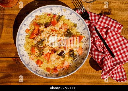 Tiefer Teller auf einem Holztisch mit hausgemachtem Hähnchen, Reis und Tomatensalat. Gesundes, natürliches, frisches Lebensmittelkonzept. Draufsicht. Stockfoto