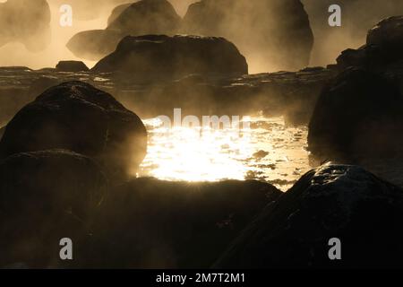Heiße Quellen und Nebel in Thailand mit Morgensonne. Morgenatmosphäre im Chae Son Nationalpark, natürliche heiße Quelle, Lampang Provinz, Thailand. Stockfoto