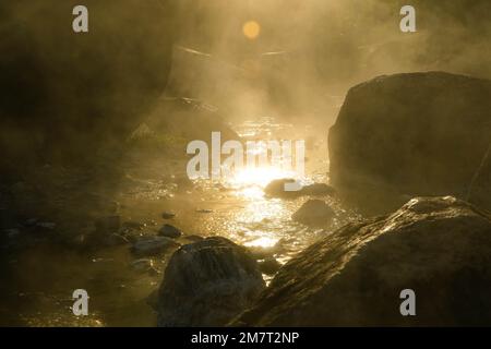 Heiße Quellen und Nebel in Thailand mit Morgensonne. Morgenatmosphäre im Chae Son Nationalpark, natürliche heiße Quelle, Lampang Provinz, Thailand. Stockfoto