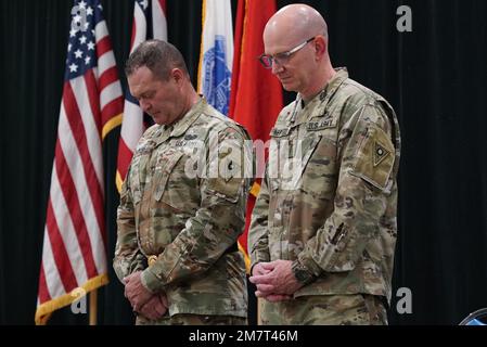 Chief Warrant Officer 4 Richard Kerwood, Ohio Army National Guard State Commandeur Chief Oversight Officer und Brig. Gen. Thomas E. Moore II., stellvertretender Generaladjutant der Armee in Ohio, beugt sich während der Berufung des Kaplans im Rahmen der Beförderungszeremonie von Kerwood am 12. Mai 2022 im Armeegebäude von Generalmajor Robert S. Beightler in Columbus, Ohio, vor. Als Oberbefehlshaber des Haftbefehls übernimmt Kerwood die Leitung, Anleitung, Ressourcen, Unterstützung und Überwachung des Ohio Army National Guard Warrant Officer Cohort. Stockfoto