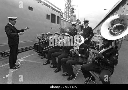 Eine US Navy Band tritt während der Inbetriebnahme der USS ANTRIM (FFG-20) auf dem Pier neben der angedockten geführten Raketenfregatte auf. Basis: Seattle Staat: Washington (WA) Land: Vereinigte Staaten von Amerika (USA) Stockfoto