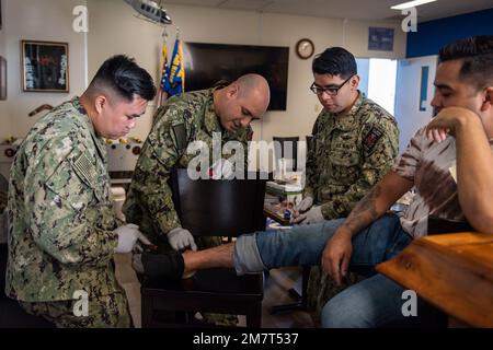 Yokosuka Naval Base Matrosen Make-up auf eine Scheinwunde in Vorbereitung auf eine medizinische Übung, 12. Mai 2022, auf Yokota Air Base, Japan. Ziel der medizinischen Übung war es, Agile Combat Beschäftigung zu praktizieren und mit Partnern zu integrieren. Stockfoto