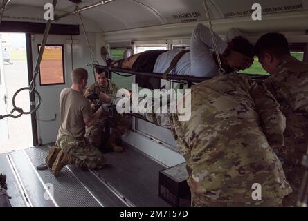 Airmen der 374. Medical Group sichern Scheinpatienten in einem Transportbus während einer medizinischen Trainingsübung, 12. Mai 2022, auf der Yokota Air Base, Japan. Die 374. Medical Group hat als Teil der Schulung multifähiger Airman-Konzepte in der Basis Aufsicht und Anleitung für die taktische Kampfnotfallversorgung bereitgestellt. Stockfoto