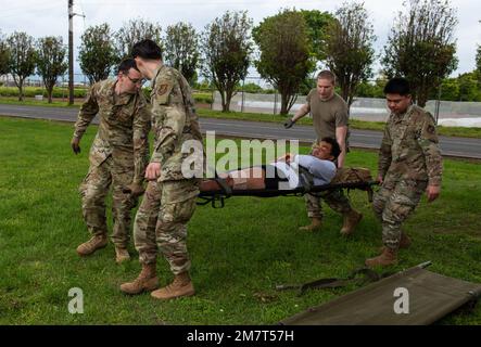 Airmen der 374. Medical Group bereiten einen stabilisierten Scheinpatienten für den Transport während einer medizinischen Trainingsübung vor, 12. Mai 2022, auf der Yokota Air Base, Japan. Sobald die Patienten gepflegt und stabilisiert sind, wird ein Team für das Staging-System unterwegs Personen mit minimalen Verletzungen in ihre Haftanstalt bringen, um auf die aeromedizinische Evakuierung zu warten. Stockfoto