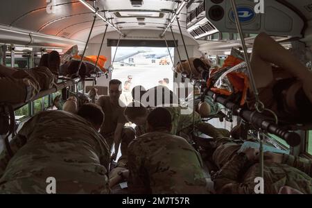 Airmen der 374. Medical Group sichern Scheinpatienten in einem Transportbus während einer medizinischen Trainingsübung, 12. Mai 2022, auf der Yokota Air Base, Japan. Die MDG 374. konzentrierte sich auf den Fluss von verletzten Patienten vom Unfallort bis zu einem Traumazentrum für eine spezialisierte lebensrettende Versorgung. Stockfoto