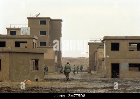 Mitglieder der 1. Panzerkavallerie bewegen sich während des Trainings in Doughboy City durch eine simulierte Stadt. Die Übung soll praktische Kampfpraktiken in städtischen Gebieten vermitteln. Betreff Betrieb/Serie: STADTSTÜTZPUNKT DOUGHBOY: Westberlin Land: Deutschland / Deutschland (DEU) Stockfoto