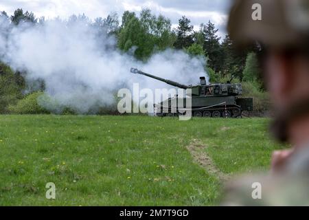 EIN US-AMERIKANISCHER Soldat sieht ukrainischen Artilleristen beim Abfeuern des selbstfahrenden Haubitzers M109 auf dem Trainingsgelände Grafenwoehr, Deutschland, am 12. Mai 2022 zu. Soldaten aus den USA und Norwegen trainierten Artilleristen der Ukraine auf den Haubitzen als Teil von Sicherheitspaketen aus ihren jeweiligen Ländern. Stockfoto