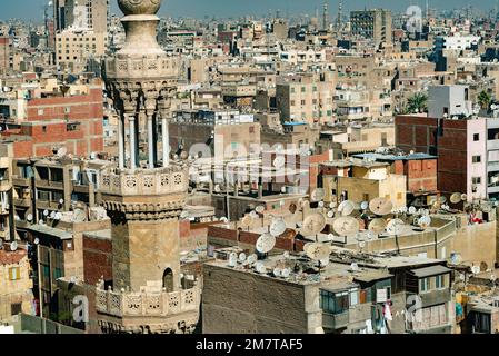 Kairo, Ägypten. November 29. 2022 Minarett der Moschee vor dem überfüllten, unvergleichlichen Stadtbild von Kairo, der dicht besiedelten Hauptstadt Ägyptens. Stockfoto