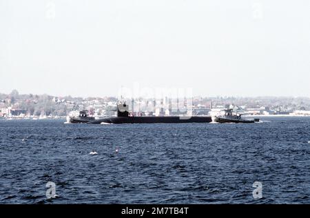 Ein Hafenblick auf das nuklearbetriebene U-Boot OHIO (SSBN-726), das nach den letzten Seeversuchen vor der Inbetriebnahme von zwei großen Hafenschleudern begleitet wird. Schlepper sind die METACOM (YTB-829) und die NEGWAGON (YTB-834). Das U-Boot wurde von der General Dynamics Corp. Gebaut Basis: U-Boot-Stützpunkt, Groton Bundesstaat: Connecticut (CT) Land: Vereinigte Staaten von Amerika (USA) Stockfoto