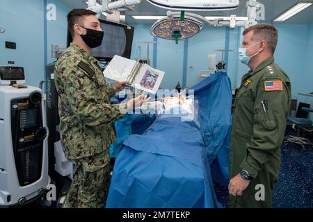 GEMEINSAME BASIS PEARL HARBOR-HICKAM, HAWAII – USA Navy Hospital Corpsman Noah Groover, aus Orange County, Kalifornien, Left, gibt Admiral Samuel J. Paparo, Commander der USA Pacific Fleet, eine Tour durch den Operationsraum an Bord des Krankenhausschiffs USNS Mercy (T-AH 19) des Militärs Sealift Command während der Teilnahme an einer Tour zur Pacific Partnership 2022. Die Pazifikpartnerschaft ist die größte multinationale Mission zur Vorbereitung auf humanitäre Hilfe und Katastrophenhilfe, die jährlich im Indo-Pazifik durchgeführt wird. Sie ist seit 17. Jahren Teil der Partnerschaft. Stockfoto