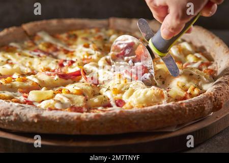 Speck, Kartoffelkäse, Pizza auf einem Schneidebrett Stockfoto