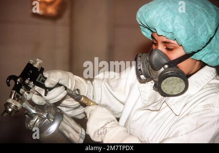 A1c Nancy M. Maese, Abteilung Korrosionsschutz, 316. Feldwartungsschwadron, trägt Schutzkleidung bei der Verwendung einer Spritzlackiermaschine. Basis: Yokota Air Base Country: Japan (JPN) Stockfoto