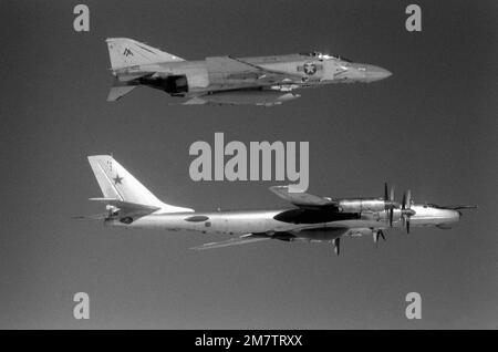 Eine Luftaufnahme eines US-Flugzeugs Navy F-4 Phantom II Flugzeug, Top, von Fighter Squadron 74 (VF-74) und ein sowjetisches TU-95 Tupolev Bear Flugzeug etwa 42 Meilen vor der Küste von Virginia. Die F-4 begleitet die in Kuba ansässige TU-95, die gerade in die US-Luftwaffenzone eingedrungen ist, um Seeversuche des neuen nuklearbetriebenen Flugzeugträgers CARL VINSON (CVN-70) aus der Vogelperspektive zu betrachten. Land: Atlantik (AOC) Stockfoto