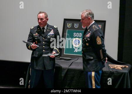 USA Armeekollege Mike Ecker, Befehlshaber der Sondereinheit der North Carolina National Guard (NCNG) X (SOD-X), überreicht Kommandodienstleiter Major Gary Beaver bei einer Zeremonie im Airborne and Special Operations Museum in Fayetteville, North Carolina, am 13. Mai 2022 ein Ruhestandsgeschenk. Die Zeremonie feierte Beavers Rücktritt von der NCNG und seine 34 Jahre Dienstzeit bei Special Operations. Stockfoto