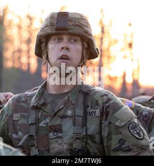 Staff Sgt. Garrett Troutt vom General Leonard Wood Army Community Hospital, Ft. Leonard Wood, Mo., atmet aus, nachdem er die Ziellinie für den Rig march überquert hat, eines der letzten Ereignisse des „Expert Field Medical Badge“-Wettbewerbs am 13. Mai 2022 in Fort McCoy, Wisconsin. Nach Abschluss des erschöpfenden 12-Meilen-Rig marschs mussten Troutt und andere Mitbewerber den Zusammenbau, die Demontage und eine Funktionsprüfung einer zugewiesenen Waffe abschließen. Stockfoto