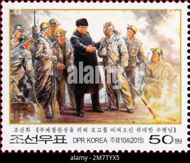 2015 Nordkorea-Stempel. 70. Jahre Gründung der Arbeiterpartei Koreas. Kim Jong Il mit Stahlarbeitern. Ölgemälde Stockfoto