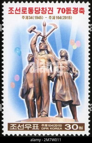 2015 Nordkorea-Stempel. 70. Jahre WPK - Arbeiterpartei Koreas. Statue vor dem Juche Tower Stockfoto