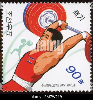 2014 nordkoreanische Briefmarke mit einem männlichen Gewichtheber in Aktion, DPRK Sportserie. Stockfoto
