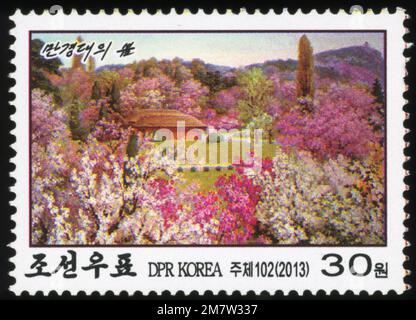 2013 Nordkorea Briefmarke mit den Mangyongdae im Frühjahr, dem Geburtsort von Kim Il-sung in Pjöngjang, mit blühenden Kirschblüten. Stockfoto