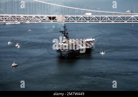 Ein Bogenblick auf den Flugzeugträger USS CORAL SEA (CV-43) unter der San Francisco-Oakland Bay Bridge. Das Schiff kehrt nach einer WESTPAC-Kreuzfahrt zum Hafen zurück. Basis: San Francisco Bay Bundesstaat: Kalifornien (CA) Land: Vereinigte Staaten von Amerika (USA) Stockfoto