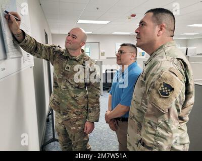 Capt. Jared Shoemaker, Defense Support of Civil Authorities Planner für die 99. Readiness Division (links) der Army Reserve, berichtet Jose Flores und Sgt. 1. Class Juan Figueroa vom 99. RD G3 während der Stabübung im Mai 13 im Hauptquartier der Division auf der Joint Base McGuire-Dix-Lakehurst, New Jersey. Im Rahmen dieser Maßnahme sollten 99. FuE-Maßnahmen zur Vorbereitung auf eine Naturkatastrophe oder vom Menschen verursachte Katastrophe und zur Reaktion darauf festgelegt und validiert werden. Stockfoto