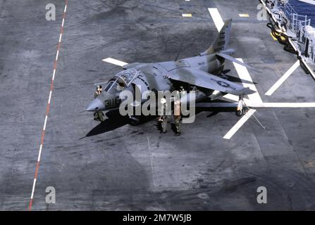 Flugdeck-Besatzungen bereiten ein AV-8A Harrier-Flugzeug für den Flug an Bord des Amphibienschiffs USS NASSAU (LHA-4) vor. Land: Atlantik (AOC) Stockfoto