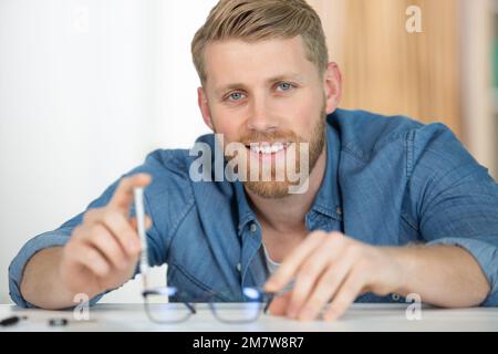 schnappschuss der Hand, die eine zerbrochene Brille hält Stockfoto