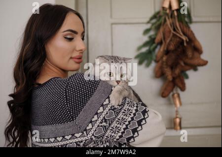 Graue Katze in den Armen einer schwangeren Frau Stockfoto