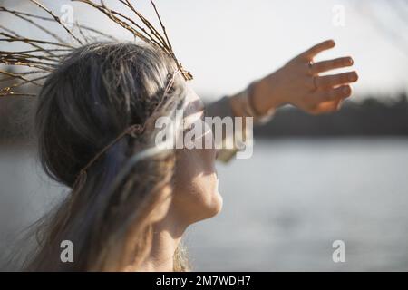 Nahaufnahme einer Frau mittleren Alters, die sich vor der Sonne versteckt, mit einem Handflächenporträt Stockfoto