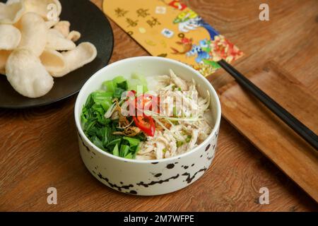 Essen am Mond-Silvester auf dem Tisch mit goldenem Umschlag gefüllt mit Geld als Zeichen des Glücks im neuen Jahr. Stockfoto