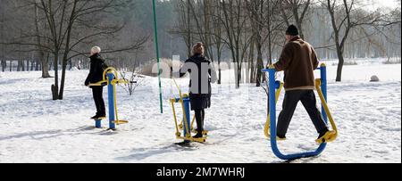 Kiew, Ukraine 25. Februar 2021: Im Winter gehen Menschen im Stadtpark auf dem Sportplatz Sport treiben Stockfoto